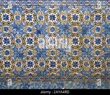 traditional blue and yellow Portuguese floral pattern glazed ceramic tires with repeating design in Stock Photo