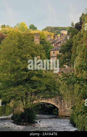 hebden bridge town in summer with packhorse bridge in summer tree lined river and buildings Stock Photo