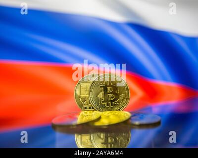 Bitcoin gold coin and defocused flag of Russia background. Virtual cryptocurrency concept. Stock Photo