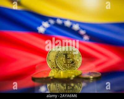 Bitcoin gold coin and defocused flag of Venezuela background. Virtual cryptocurrency concept. Stock Photo