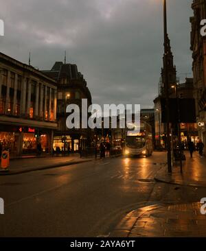 Leeds, England - January 18, 2018: commuters and bus on the street in boar lane in leeds city centre in the evening with illumin Stock Photo