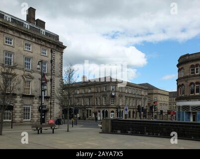 Huddersfield, West Yorkshire, England - April 26, 2018: Pedestrians in St Georges Square walk past the historic old stone buildi Stock Photo