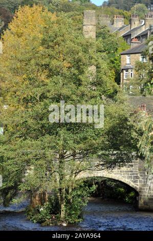 hebden bridge town in summer with packhorse bridge crossing the river calder and stone buildings in summer with bright sky and t Stock Photo