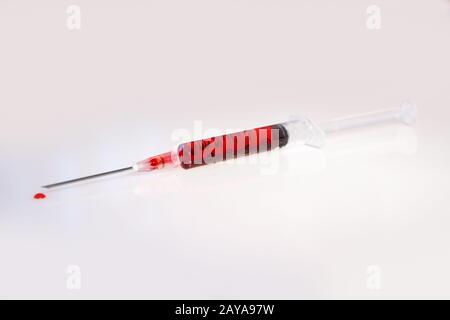 Syringe with blood on white background Stock Photo