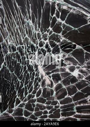 close up of shattered glass with white cracks on a black background Stock Photo