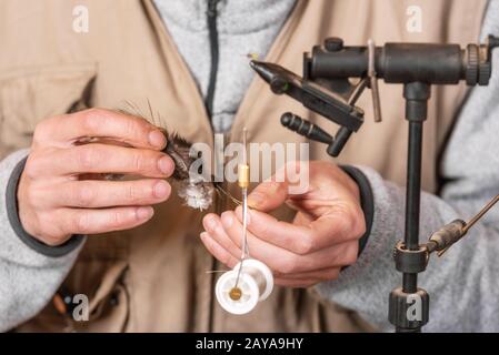 Man making trout flies. Fly tying equipment and material for fly fishing  preparation Stock Photo - Alamy