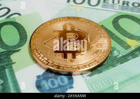 Close-up of Bitcoin coins on 100 Euro banknotes. Crypto currency BTC. Stock Photo