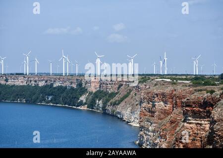 Panoramic view from the bay and wind turbine generators power energy park on sea shore landscape Stock Photo