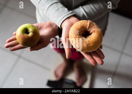 woman hold an apple and donuts Stock Photo