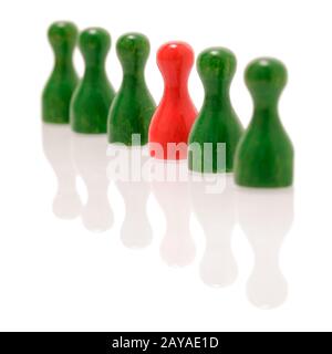 Row of wooden green figures and one red figure. Teamwork Stock Photo