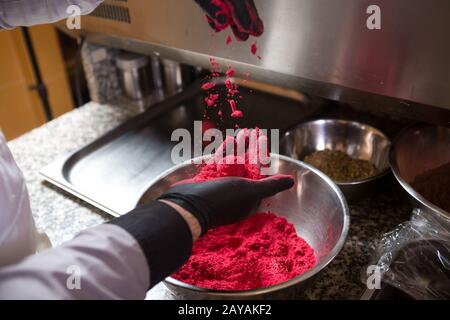 Theme cooking chocolates truffle. Close-up hand Young Caucasian woman and man cook with tattoo and in uniform prepares, makes ro Stock Photo