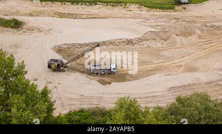 Tod down view of excavator loading dump truck. On the construction site. Stock Photo