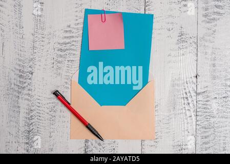 Front view open colored rectangular envelope blank sheet paper sticky note ballpoint lying retro vintage rustic old lumber timbe Stock Photo