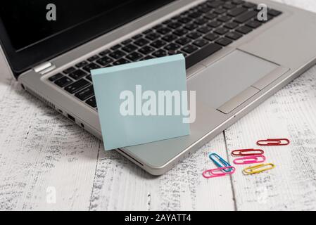 Trendy metallic laptop sticky notes colored clips lying wooden rustic vintage table. Personal computer timber desktop blank empt Stock Photo