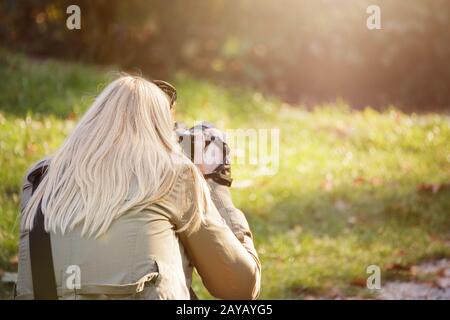 Female photographer outdoors shooting with her dslr. Photography, creativity and hobby concept. Stock Photo