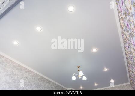 An outline of a stretch ceiling in a room with a chandelier and spotlights Stock Photo