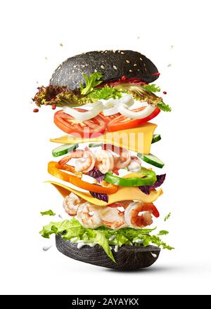 Flying burger with shrimp and fresh vegetables on a white background. Stock Photo