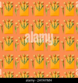 Decorative pattern with gift envelopes of tulips flowers on an orange. Stock Photo