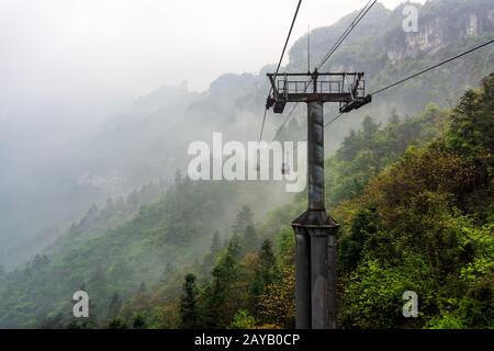 Cable way vanishing in mist or fog in Tianmen Mountain Stock Photo