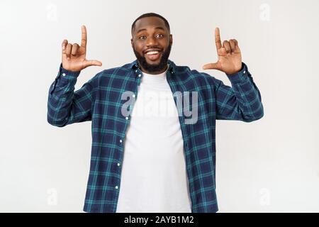 Young amazed African American pointing his finger at white background with copy space for your advertisement Stock Photo
