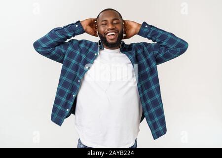 Handsome Afro American man in casual clothes is listening to music using a smart phone and smiling. Stock Photo
