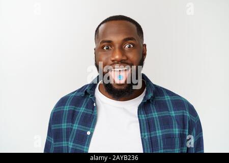Studio shot of young African American man with candy in mouth against gray background Stock Photo