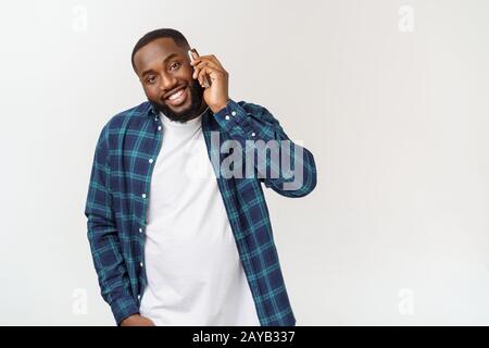 Young black man smiling and talking on mobile phone. Stock Photo
