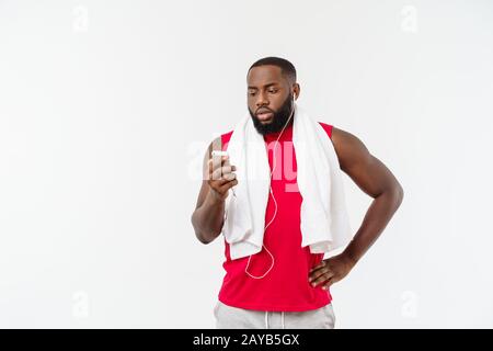 Handsome African American man listening music on his mobile device after sport exercise. Stock Photo