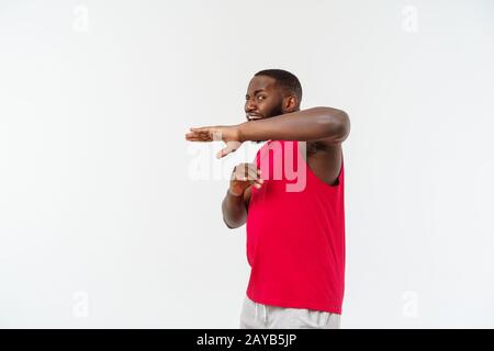 Funny and playful adult African American guy standing in profile in martial arts pose with raised palms, frowning and staring. Stock Photo