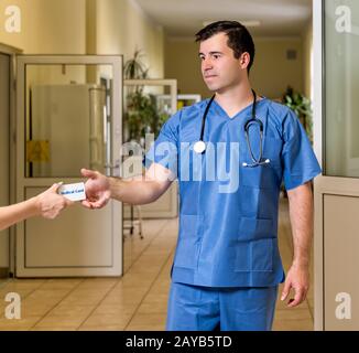 Middle age male doctor in scrubs accepting Medical Card Stock Photo