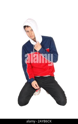 Happy young man kneeling on the floor resting from exercise Stock Photo