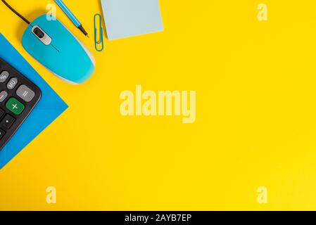 Front view closed envelope clip binder pencil marker sticky note calculator computer wire mouse gadget colored background Empty Stock Photo