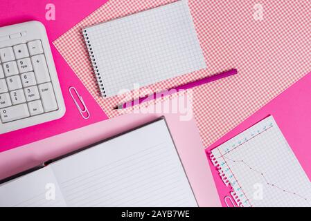 Writing equipments and computer stuffs plus mathematic paper placed on a colored backdrop. Stationary, thick book near tools of Stock Photo