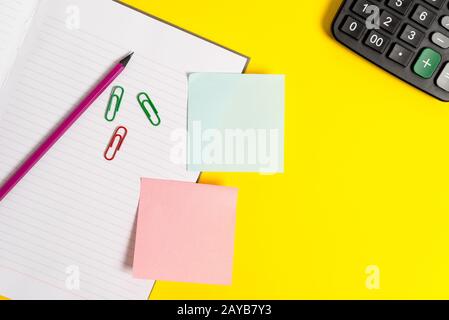 Empty blue paper with copy space paper clips and pencils on the yellow table. Blank paper for text messages. Business concept wi Stock Photo