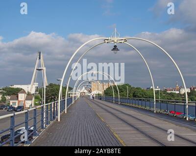 southport, merseyside, united kingdom - 28 july 2019: the historic pier in southport merseyside with people walking towards the Stock Photo