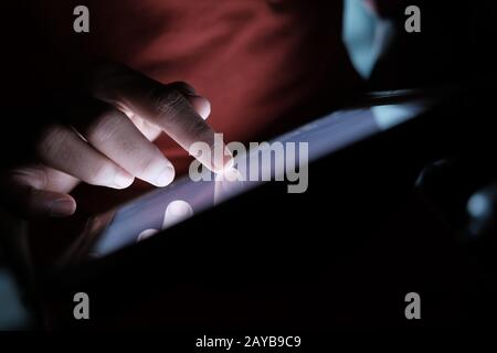 young man use digital tablet at night, close up  Stock Photo