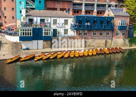 Line of moored rowing boats on the banks of River Wear near a boat club in Durham, United Kingdom on a beautiful spring afternoo Stock Photo