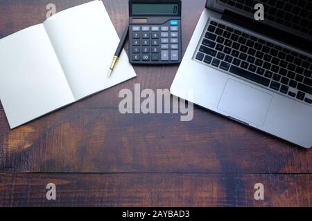 top view of notepad, calculator and laptop on table  Stock Photo