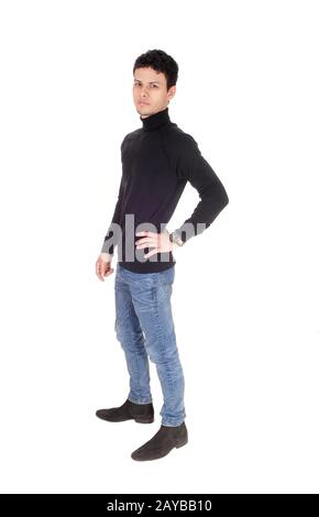 Handsome tall young man standing in jeans in the studio Stock Photo