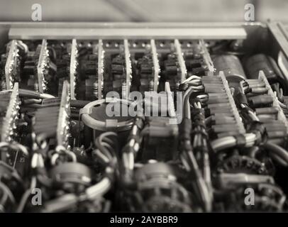 monochrome selective focus image of complex colored wiring and connectors joining circuit boards with electrical components Stock Photo