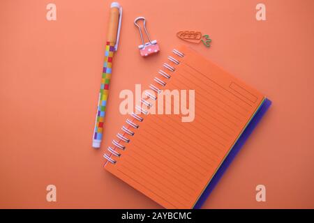 top view of notepad and pen on orange background  Stock Photo