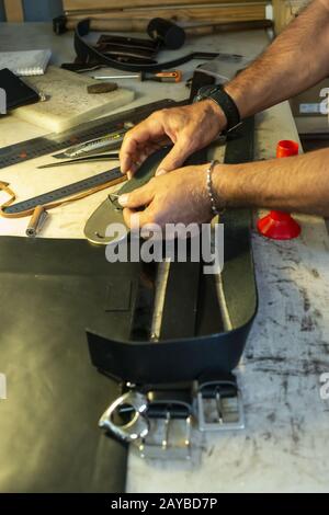 Tailor process leather in workshop. Stock Photo