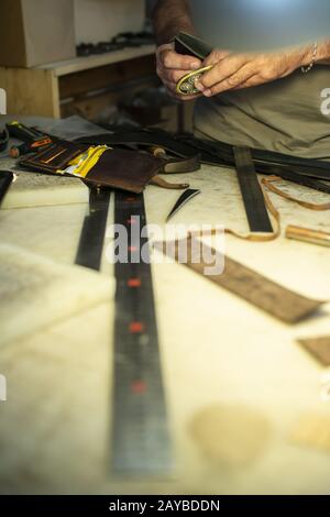 Tailor process leather in workshop. Stock Photo