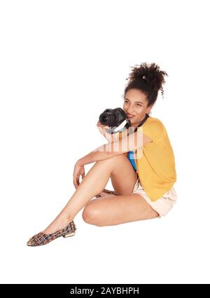A multi-racial woman sitting on the floor with her camera Stock Photo