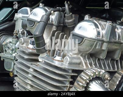 close up of a large of a large old motorcycle engine on a black frame with shiny chrome bolts and pipes Stock Photo