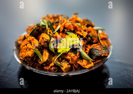 Famous Indian & Gujarati snack dish in a glass plate on wooden surface i.e. Patra or paatra consisting of mainly Colocasia esculenta or arbi ke pan or Stock Photo