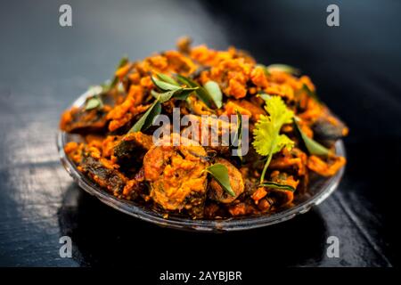 Famous Indian & Gujarati snack dish in a glass plate on wooden surface i.e. Patra or paatra consisting of mainly Colocasia esculenta or arbi ke pan or Stock Photo