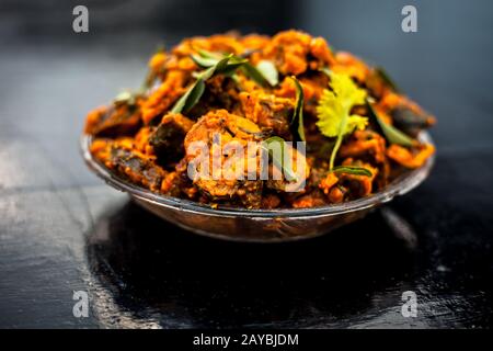 Famous Indian & Gujarati snack dish in a glass plate on wooden surface i.e. Patra or paatra consisting of mainly Colocasia esculenta or arbi ke pan or Stock Photo