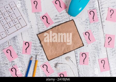 Writing equipment and computer stuff plus scribbled paper placed on a wooden backdrop. Stationary, note sheet near tools of data Stock Photo