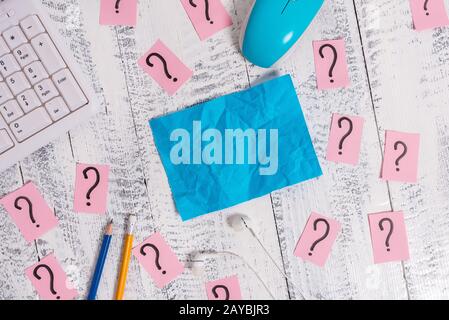 Writing equipment and computer stuff plus scribbled paper placed on a wooden backdrop. Stationary, note sheet near tools of data Stock Photo